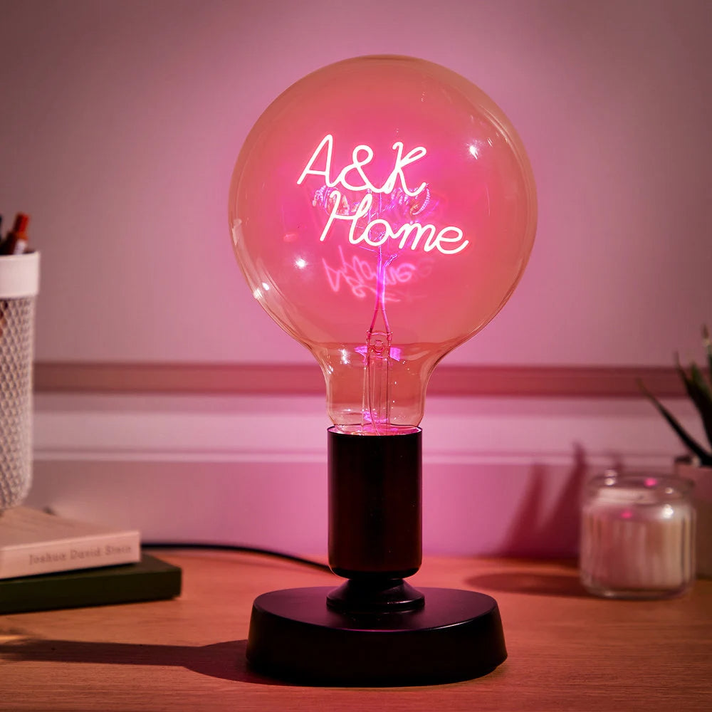 Personalized Edison bulb table lamp with a custom text filament pink light